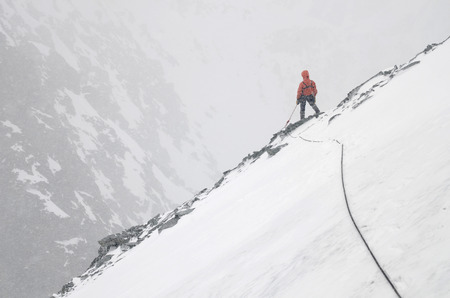 A Mountain climber with rope on the slope. Ascent on Metallurg Peak. Altai Republic, Russiaの写真素材