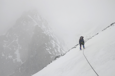 A girl mountain climber with rope on the slope. Ascent on Metallurg Peak. Altai Republic, Russiaの写真素材