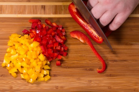 The chef cuts the peppers on a cutting Boardの写真素材