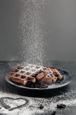 Sprinkling with sugar powder Viennese waffles. Heart shape on sugar powderの写真素材