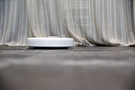working robot vacuum cleaner, gray tiles, porcelain tiles, stone, gray background, beige curtains, home comfort, textiles, cleaning, kitchenの写真素材