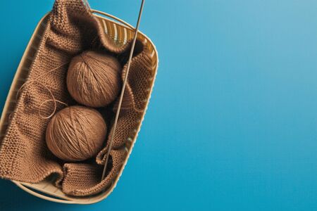 Winter needlework. Balls of wool yarn for hand knitting and knitting pins per s. Place for text....