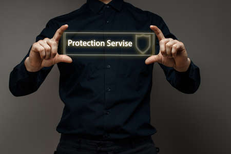 Businessman holds a virtual sign with the text protection service. Data protection concept, computer securityの写真素材