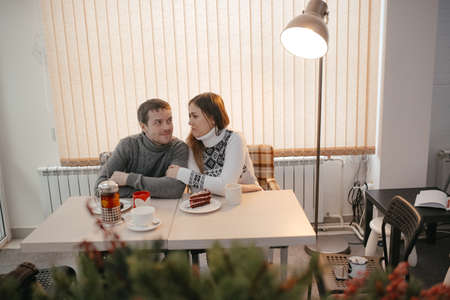 Couple in love is relaxing in a cafe. The Couple Is A Beautiful Young Man And Woman. A couple drinks tea. People Look at Each Other. .People are happy and smiling. Daytime.の写真素材