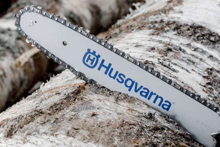 KIROV, Russia - 09.10.2020. Husqvarna 236 Chainsaw. Man saws a log with a chainsaw, prepares firewood for winter, hard rural workのeditorial素材