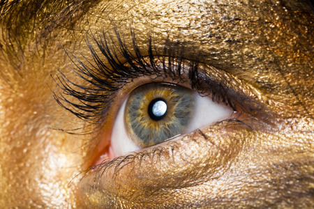 Creative make-up technique: golden paint, macro shotの写真素材