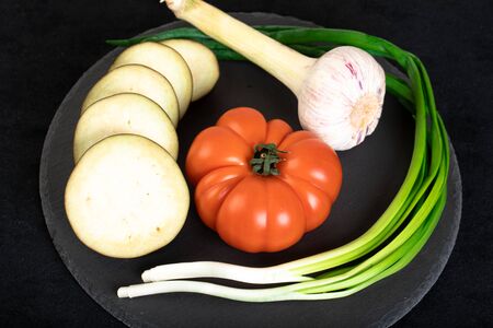 Assorted vegetables ob black wooden plateの写真素材
