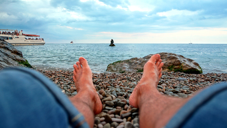 feet resting on a sculpture of mermaids in Miskhorの写真素材
