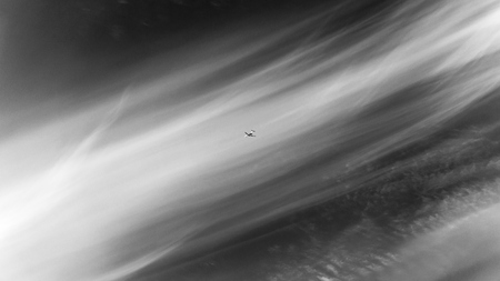 the plane is flying in the sky in the traces of the clouds