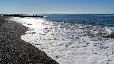 sea waves in the surf illuminated by the blinding sunの写真素材