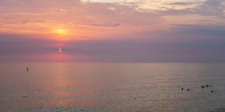 Sunset on the sea in the clouds with sun raysの写真素材