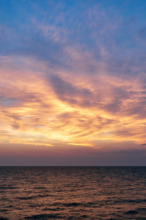 Sunset on the sea in the clouds with sun raysの写真素材