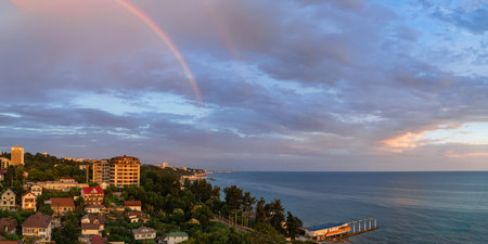 In the distance, there is a large body of water with a city skyline on sunsetの写真素材