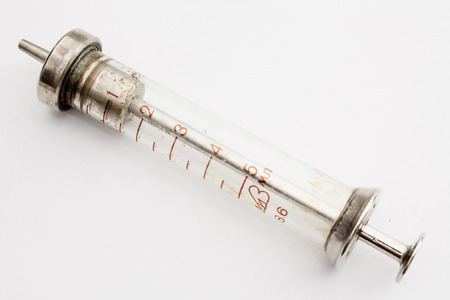 old syringe close-up shot on white backgroundの写真素材