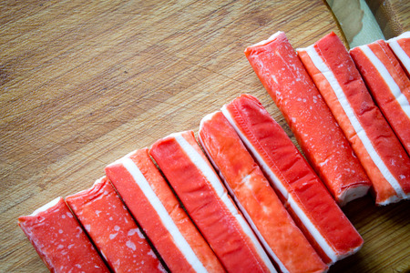 frozen crab sticks on a wooden boardの写真素材