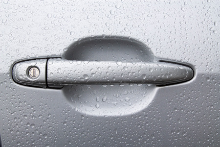 car door handle in raindrops close upの写真素材