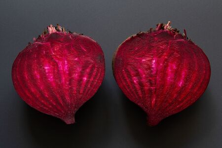 Two parts raw ââbeetroot on black backgroundの写真素材