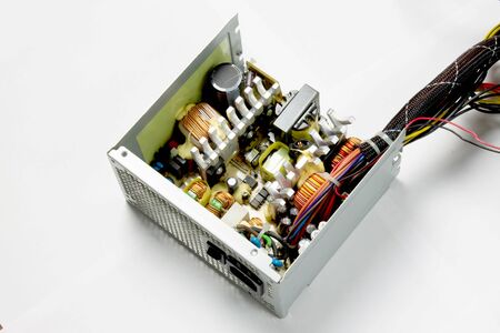 Disassembled computer power supply on white background