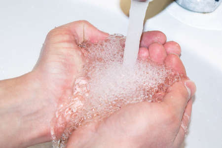 Washing hands under the water tapの写真素材