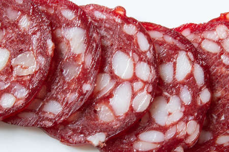 Slices of smoked sausage close up on white backgroundの写真素材