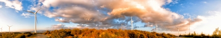 Panoramic view of a group of windmills opposite dramatic skyの写真素材