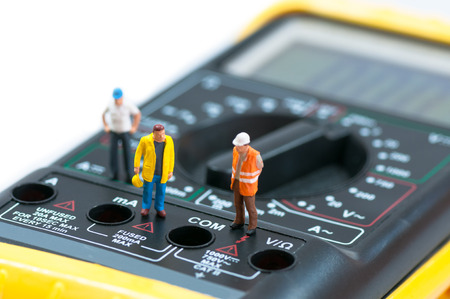 Miniature workers on top of multimeter  Macro photoの写真素材