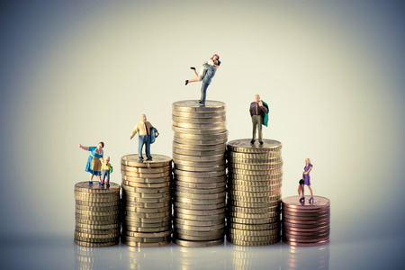 Faily budget concept. Miniature family on coins pile. Macro photo Faily budget concept. Miniature family on coins pile. Macro photo