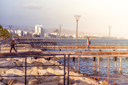 LIMASSOL, CYPRUS - March 08, 2016: Limassol's seafront wooden piers with walking people.のeditorial素材