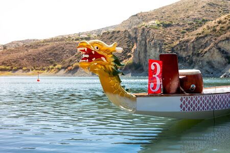 A brightly coloured Dragon Boat on the riverの写真素材