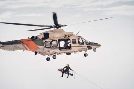 Search and rescue SAR helicopter team hoists an injured personの写真素材