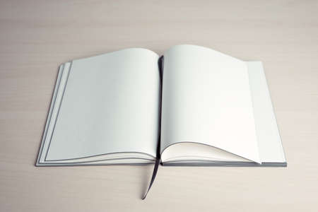 Opened book with blank pages on top of wooden tableの写真素材