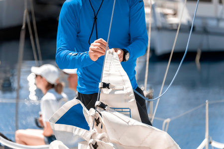 Midsection of a yachtsman checking sail before competitionの写真素材