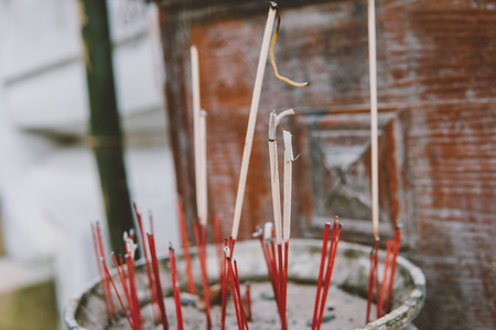 Smoldering incense in a Buddhist temple close-up. Excursions on Buddhist temples and pagodas of Thailandの写真素材