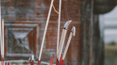 Smoldering incense in a Buddhist temple close-up. Excursions on Buddhist temples and pagodas of Thailandの写真素材