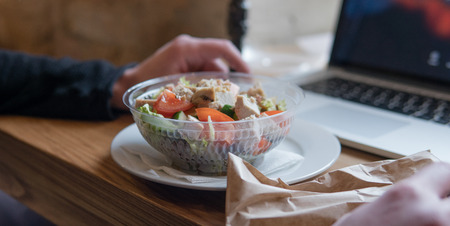 Take away salad with  tomatoes and chicken in plastic packaging. A useful snack for office workers in the workplaceの写真素材