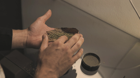 Roll a weed buds blunt in man hands close-up. twisting  jointwith the buds of marijuana inside.