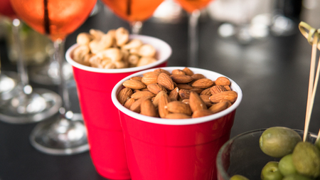 almonds and cashew in a red glass. Useful properties of almonds and cashews