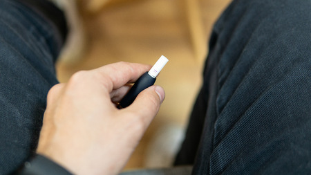 Man holding electronic cigarette system. Heating tobacco technologyの写真素材