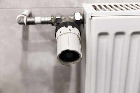 Temperature control knob on room battery. Metal radiator with individual control. heating system, energy crisis, energy saving, heat saving, heating season. High quality photoの写真素材