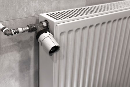 Temperature control knob on room battery. Metal radiator with individual control. heating system, energy crisis, energy saving, heat saving, heating season. High quality photoの写真素材