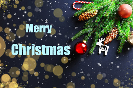 Merry Christmas text with snow, light bokeh, fir branches, pine cones, and red bauble ornaments on a dark background. High quality photoの写真素材