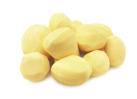 A pile of several raw, freshly peeled yellow potatoes, ready for cooking and isolated on a clean white background. High quality photoの写真素材