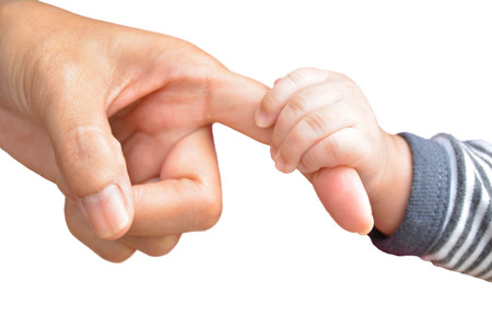 Hand of baby holding finger of adult on white background isolateの写真素材