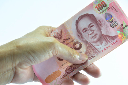 Hang of human holding banknote  of Thailand on white background isolate