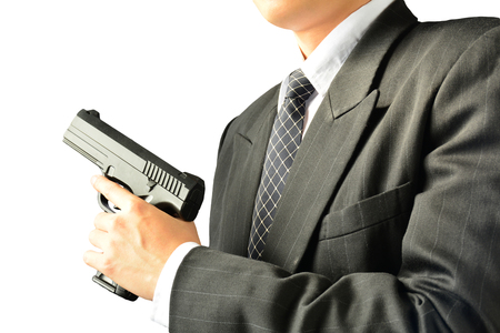 Man or businessman holding gun front of his body on white background isolateの写真素材