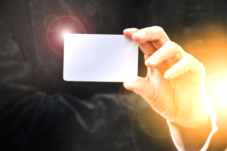 Hand of woman holding the white card flare light corner of card and under the sunlightの写真素材