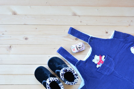 Shoes and wear of baby or child on wood table top view under nature lightの写真素材