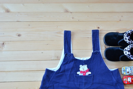 Shoes and wear of baby or child on wood table top view under nature lightの写真素材