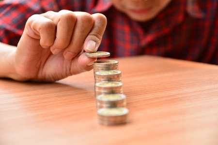 Saving money concept and hand putting money coin stack growing for businessの写真素材