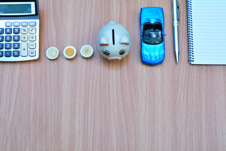 Car insurance concept with calculator, pen and notebook on wood tableの写真素材